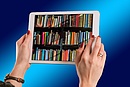 Zwei Hände halten ein Tablet, auf dem ein mit Büchern gefülltes Regal abgebildet ist