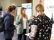 Studierende lassen sich beim Stand der Landesarbeitergemeinschaft beraten
