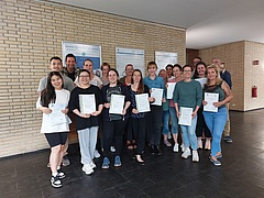 Teilnehmer:innen des Zertifikatskurses mit den Dozierenden Daniel Mauter (EHB), Prof. Dr. Sven Lück (EHB) und Oliver Schadow (theroga). In den Händen halten sie ihre Zertifikate der Deutschen Schmerzgesellschaft und/oder die Teilnahmebescheinigung des ZFW.