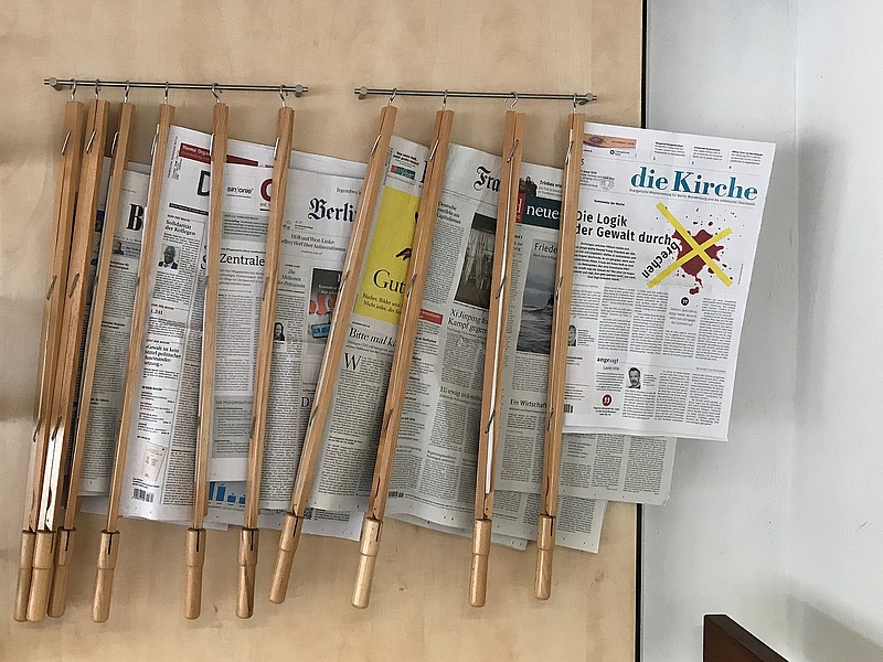 Zeitungen an Zeitungshalterstangen