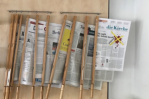 Zeitungen an Zeitungshalterstangen