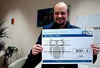 Der Rektor präsentiert den symbolischen Scheck