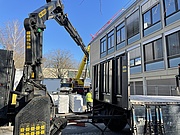 Ein Kran befördert Baumaterial für das neuen Dach des Auditorium Maximum am F-Gebäude