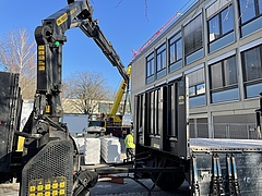 Blick auf die Seitefassade Hauptgebäude mit Baustelle und gelbem Lastkran links davor