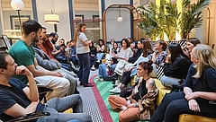 Große Gruppe von jungen Menschen sitzt sich gegenüber