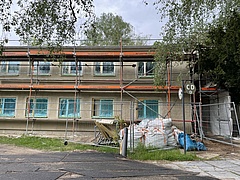 Ein Gerüst steht vor einem Gebäude an dem die Fassade noch in der Bauphase ist